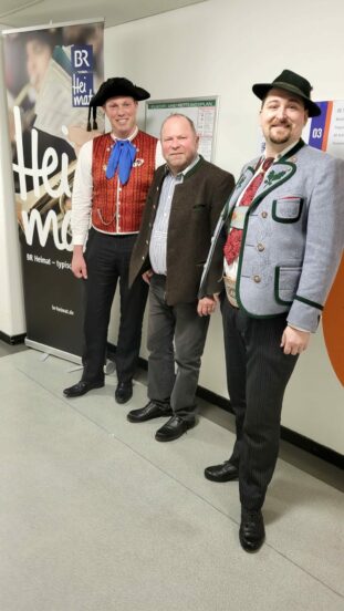 Matthias Wiesheu (rechts) und Florian Kreß zusammen mit Stefan Frühbeis vor dem BR Heimat Studio