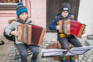 Hannes Astner, Neubeuern und Leo Hermann, Samerberg (beide 8 Jahre jung) unterhalten die Besucher auf dem Marktplatz von Neubeuern beim Warenmarkt