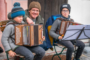 Hannes Astner, Neubeuern und Leo Hermann, Samerberg (beide 8 Jahre jung) unterhalten die Besucher auf dem Marktplatz von Neubeuern beim Warenmarkt